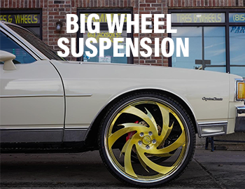 Image of a 1970-1990 Chevy Caprice Classic (Box) with big gold wheels and QA1 suspension with a text overlay that reads 