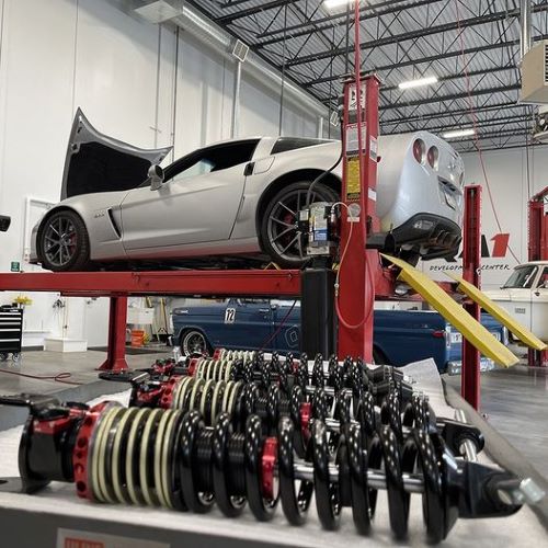 C5 C6 Corvette on a lift with QA1 adjustable shocks pictured